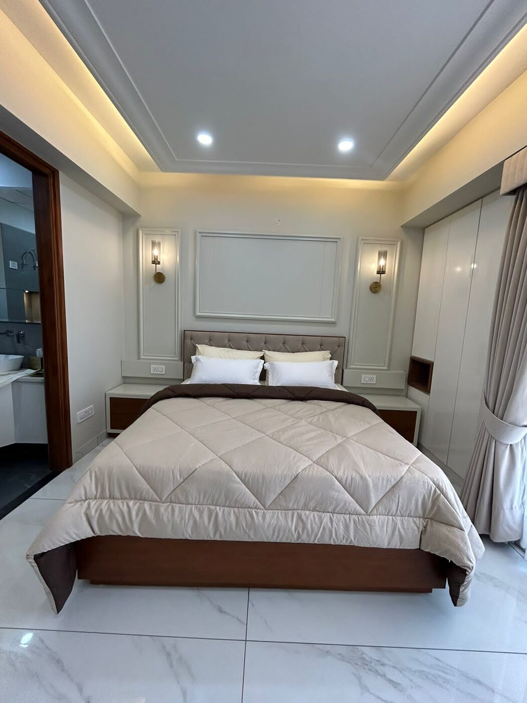 Bedroom with upholstered headboard and an attached bathroom off it — Absolute Residency, Sector 92 Mohali