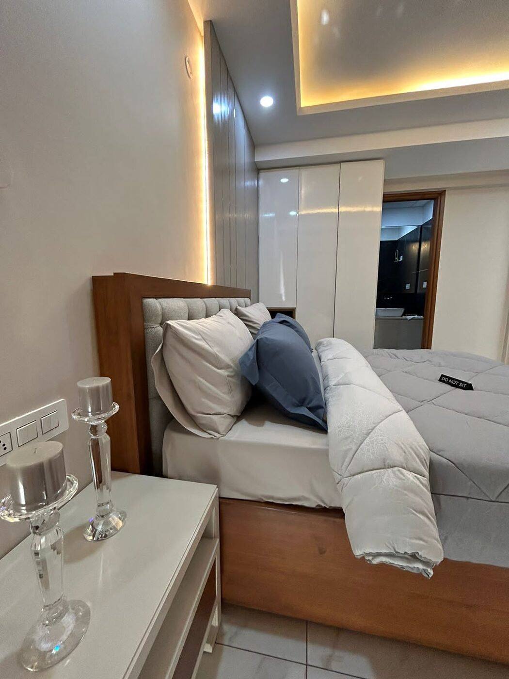 Bedroom with full-height gloss wardrobes and an attached bathroom beyond — Absolute Residency, Sector 92 Mohali