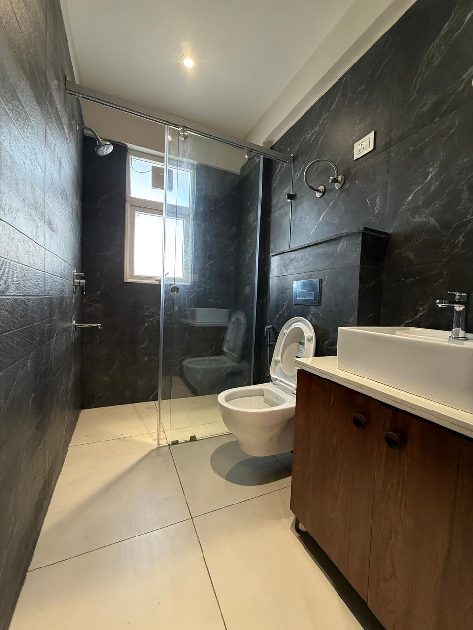 Attached bathroom in dark stone — The Grandeur, Sector 117 Mohali