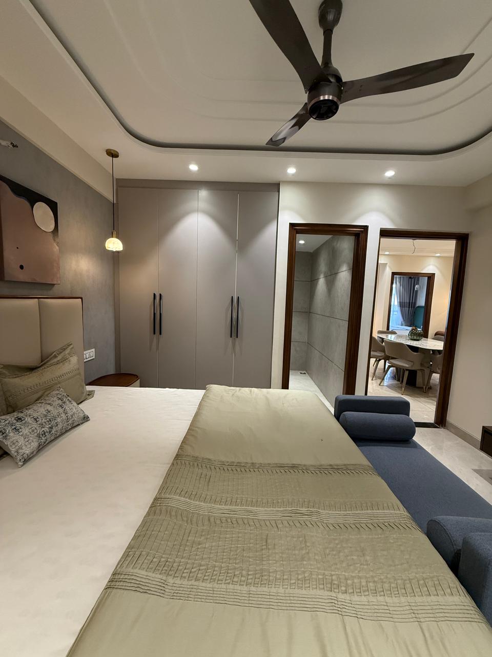 Bedroom with fitted wardrobes, attached bathroom and the dining beyond — The Grandeur, Sector 117 Mohali