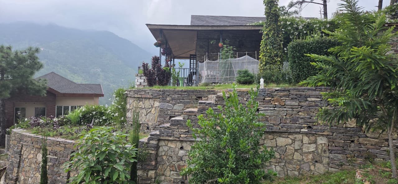 Dry-stone retaining terraces below a covered pavilion — Himachal Pradesh