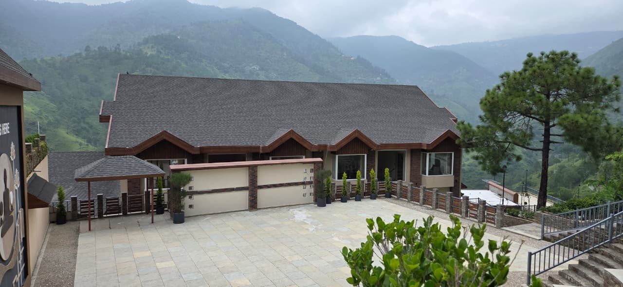 Single-storey building with a shingle roof and a paved forecourt — Himachal Pradesh