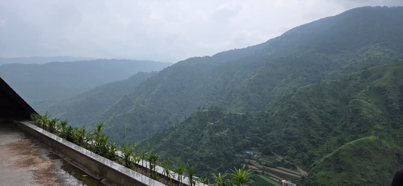 A forested Himachal valley under cloud